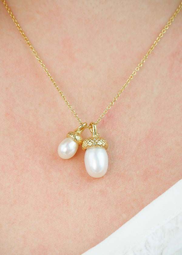 solid gold pearl acorn necklace worn by a model